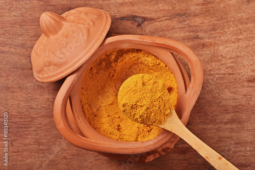 Dry curry powder in bowl on wooden table