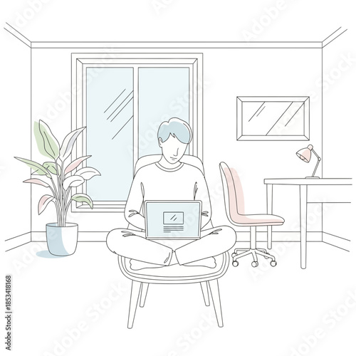 Young man working on laptop in cozy home office, cross-legged on chair