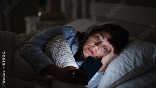 Woman in Bed at Night Using Smartphone.