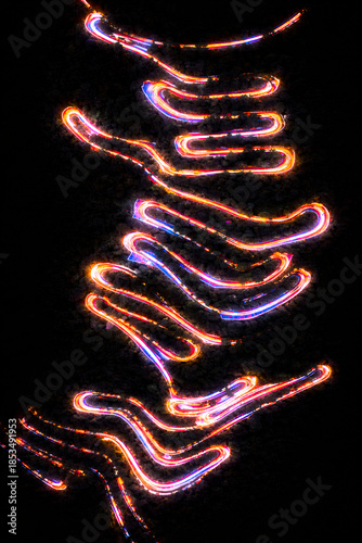 Aerial night view of a road in Trichy city kolli hills though dark forest, captured in long exposure, with vibrant neon light trails forming glowing, serpentine patterns against the black landscape.