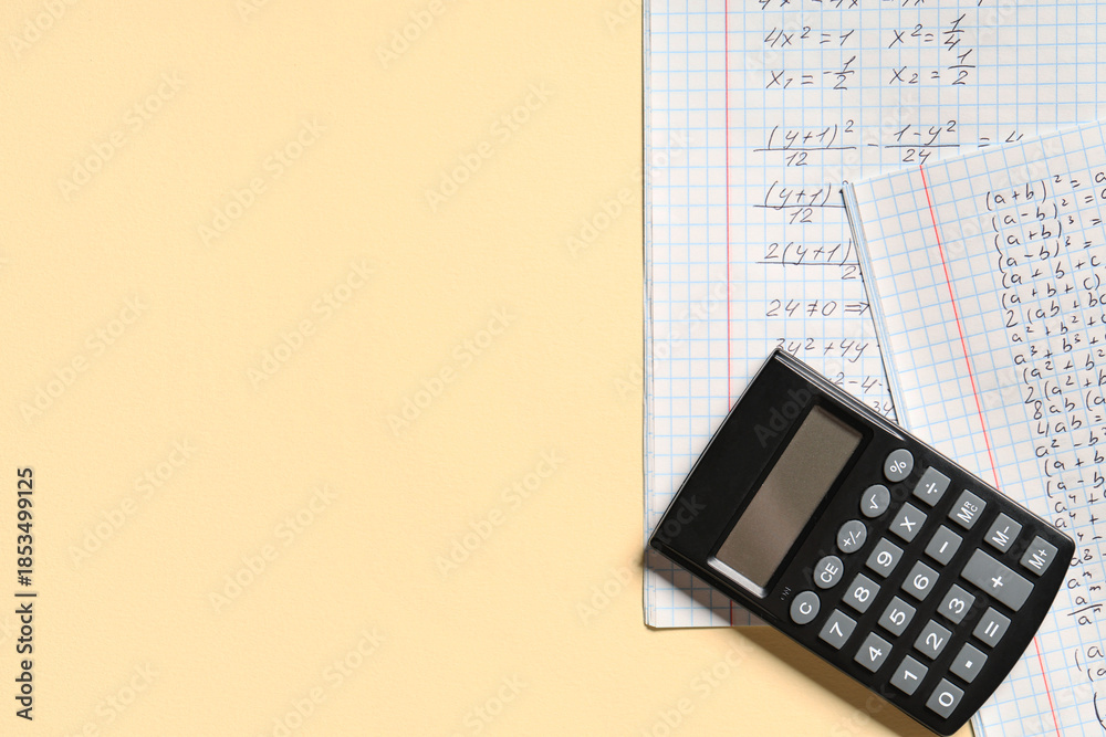 Naklejka premium Copybook with handwritten maths formulas and calculator on yellow background