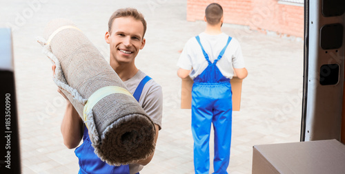 Male mover taking rolled ca...