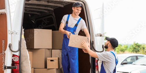 Cuadro en lienzo Male movers unloading box from car outdoors