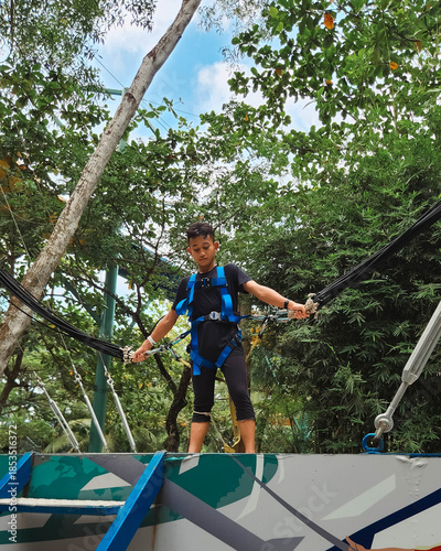 Malaysia, Penang - November 22, 2024 Teenage boy on the Jumping Jack, the giant trampoline in Escape Park.