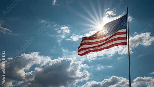 Sunlight bursts through clouds, illuminating a waving flag against blue sky