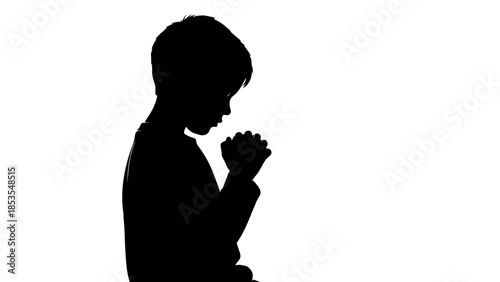 A silhouette of a young boy with hands clasped appearing to pray or contemplate