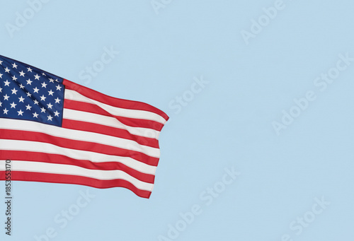 Elegant American flag ripples gently against clear sky conveying patriotism. Copy space for brand poster or banner.