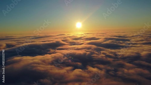 Sunset landscape above the cloud layer. Aerial view above the sea of ​​clouds with the sun setting