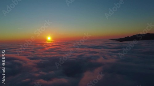 A stunning view of a sunrise or sunset from above the clouds. A breathtaking view of either a sunrise or a sunset taken from an aerial perspective above a thick layer of clouds