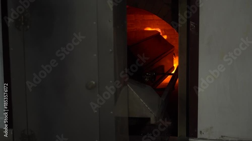 A coffin with a corpse is rolled into the flames of the crematorium and burned