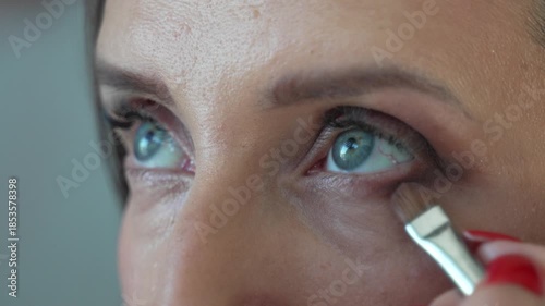 Professional Makeup Application Eyeshadow Artist Applying Dark Liner to Beautiful Blue Eyes