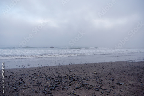 Pebbled shoreline and misty horizon at Ruby Beach in Washington State, USA