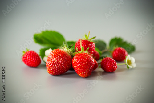 Fresh strawberries of juicy red color on a minimalistic background
