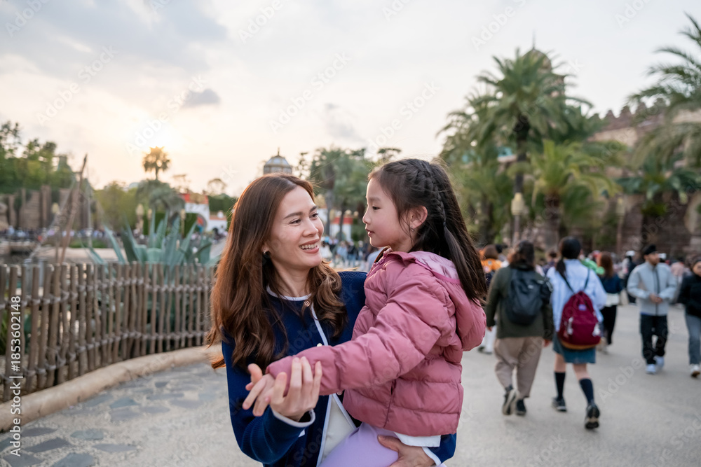 Obraz premium Asian mother and adorable daughter traveling together at theme park. 
