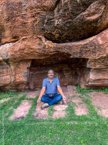 Man performing Yoga on top of the hill.