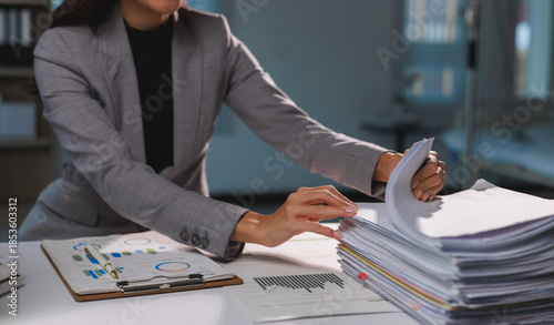 Billede på lærred Businesswoman organizing financial reports working late in office