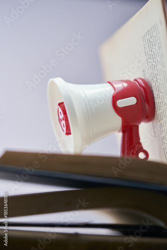 Small megaphone on top of open book.