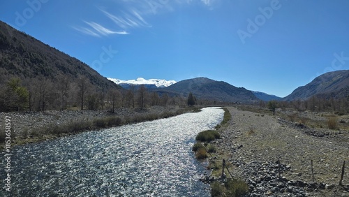 Stunning view of Río Maichín on a sunny day in southern Chile. Clear river waters, surrounding forest, and bright natural light create a vibrant and peaceful landscape.