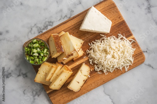A cutting board with slices of different vegan cheeses