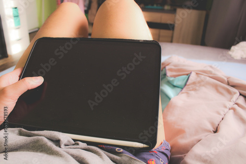 POV of person using tablet with stylus pen on bed, concept of digital nomad and mobile working.