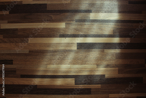 Top view of wooden parquet texture background with natural light and shadows.