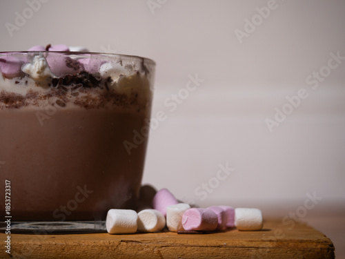 Sprinkling toppings on hot chocolate with marshmallows