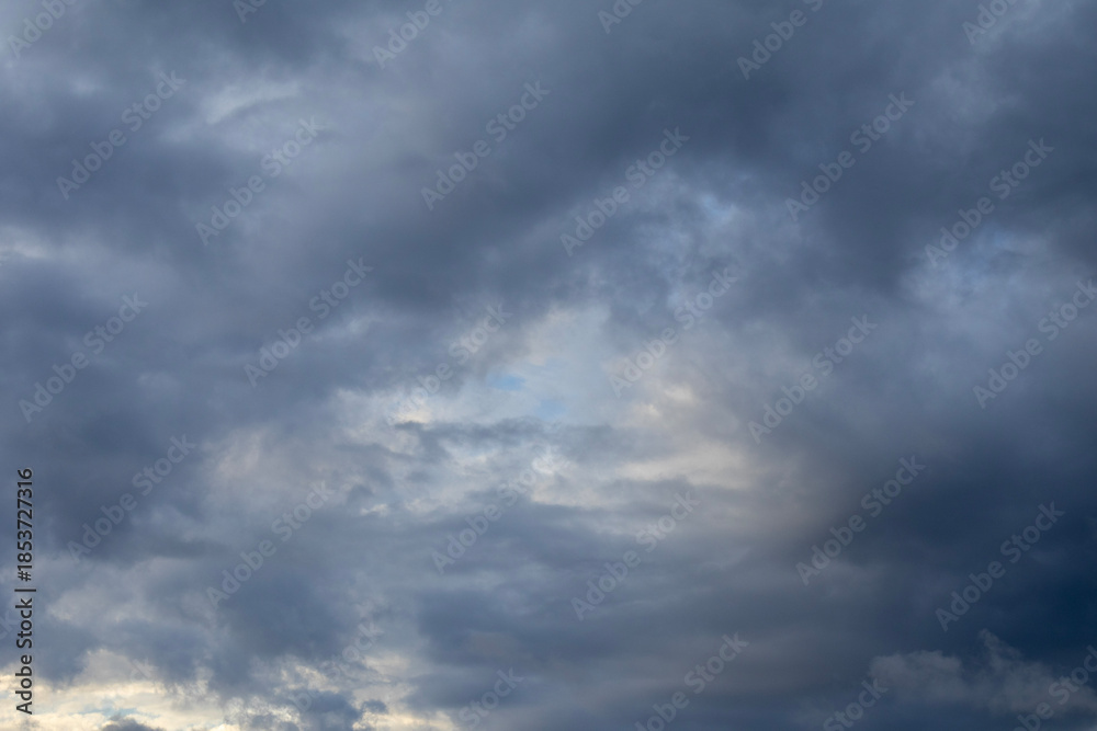 Fototapeta premium Dramatic storm clouds illuminated by soft sunset light in evening sky