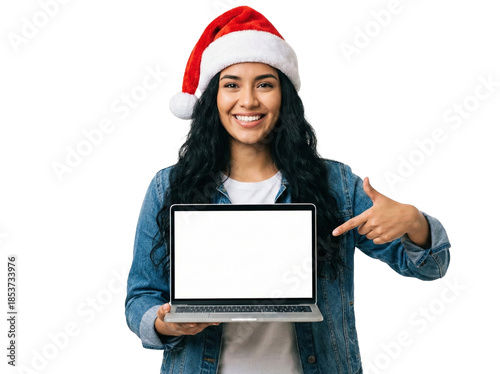 Happy young woman in Santa hat holding laptop and pointing at blank white screen isolated on white background
