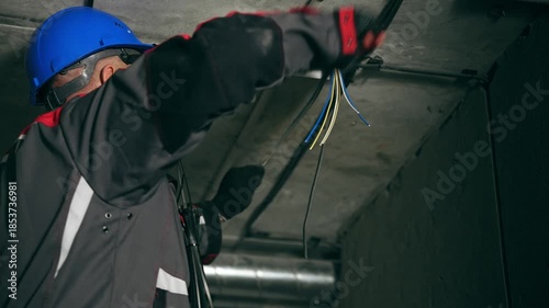 Experienced Male Electrical Specialist Meticulously Installing Ceiling Wiring With Safety Protocols In Place