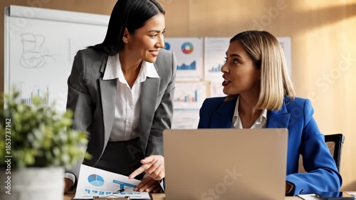 Two professional women looking at laptop screen with surprise and analysis