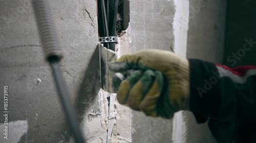 Skilled Worker Meticulously Presses Filler Into Tight Space Surrounding Interior Conduit For Seamless Finish