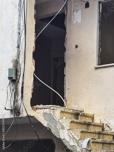 Ruined Building Facade with Exposed Brick and Broken Stairs