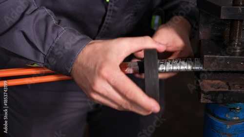Detailed Image Showing Technician Stripping Steel Braid From Cable Using Vise Under Bright Workshop Light