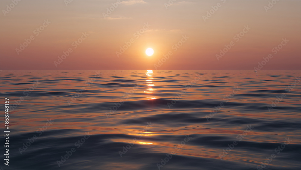 Obraz premium Serene ocean surface under a soft orange sunset with gentle waves reflecting golden light across the water