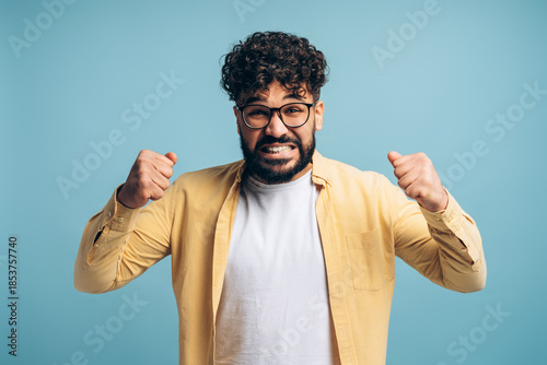 Quadro em tela Angry middle eastern man celebrating victory with clenched fists looking at came