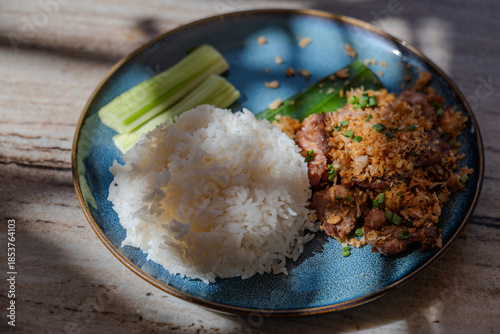 Thai's style main dish for lunch made from steamed rice serving with sliced pock stir fried with garlic