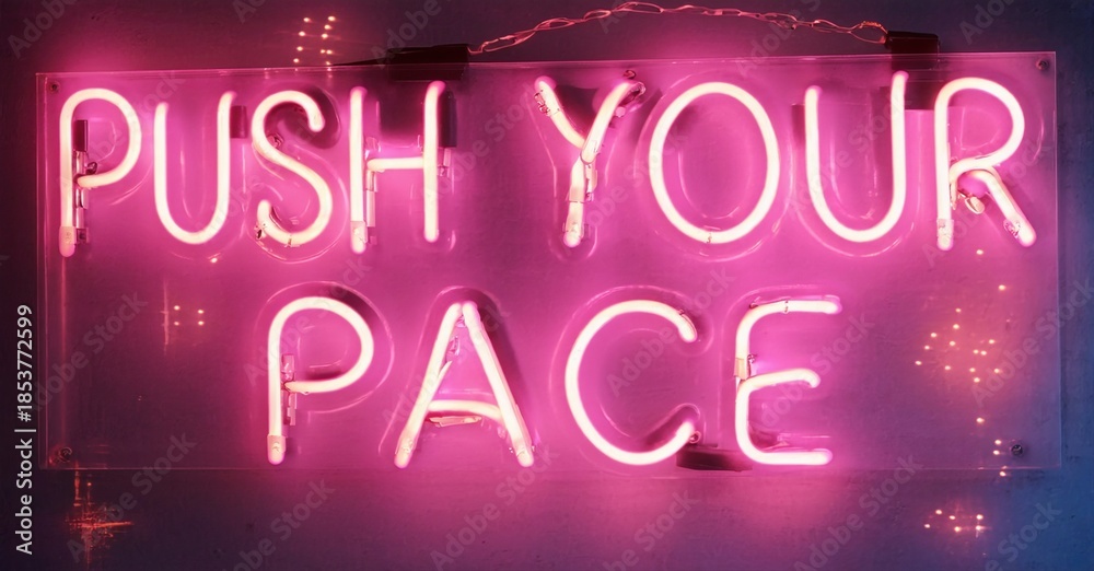 Fototapeta premium Bright pink neon sign displays motivational phrase push your pace. Dark background emphasizes glowing text. Simple, direct message.