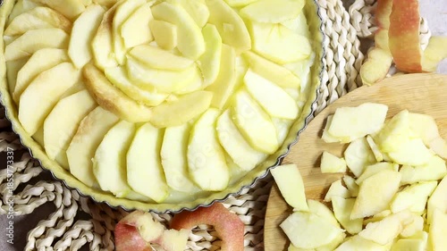 Woman preparing Apple Tart Pie Centered on Rustic Plaited Doily with Fresh Apple Slices and Cutlery