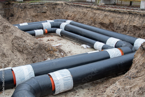 Foto Insulated district heating pipes installation in deep urban trench