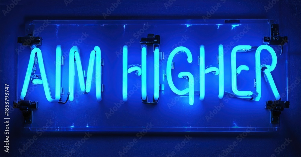 Fototapeta premium Bright blue neon sign displays text AIM HIGHER. Background is dark gray wall. Simple, motivational message.