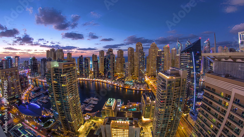 Принти на полотні Modern skyscrapers and water channel with boats of Dubai Marina at sunset and day to night timelapse, United Arab Emirates