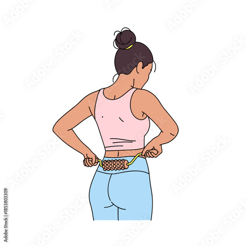 Young woman using wooden roller for back massage at home  