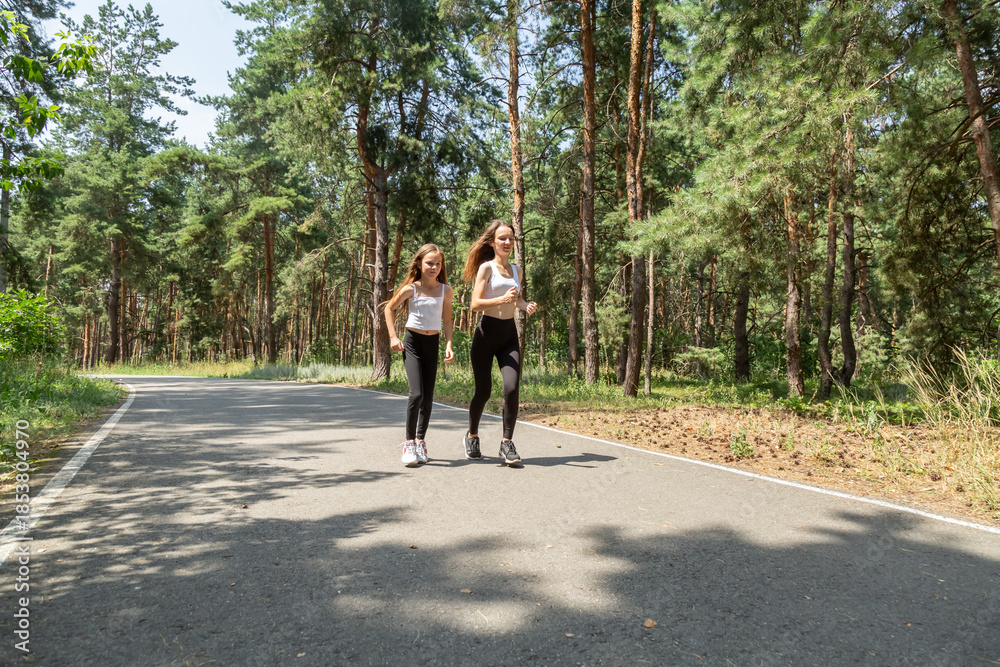 Obraz premium Mother and daughter walking in the forest on a summer day.
