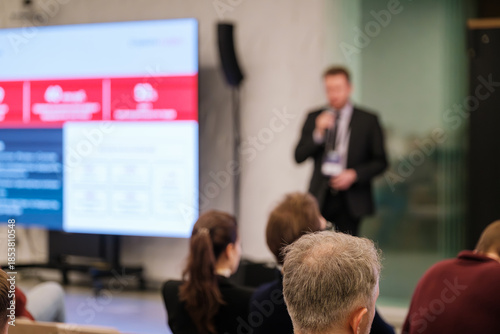 Billede på lærred Presenter speaks at conference while audience watches large screen
