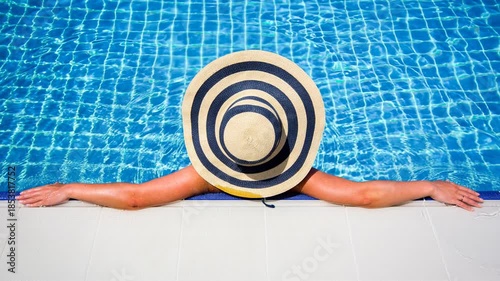 Woman in straw hat relaxing swimming pool. The video is generated from my real photo.