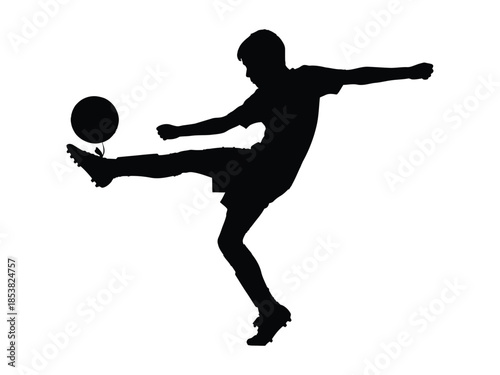Silhouette of a young athlete kicking a soccer ball with energy