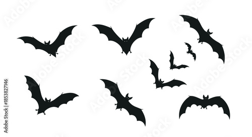 Group of various black bat silhouettes flying in different directions against a white background for spooky Halloween designs.