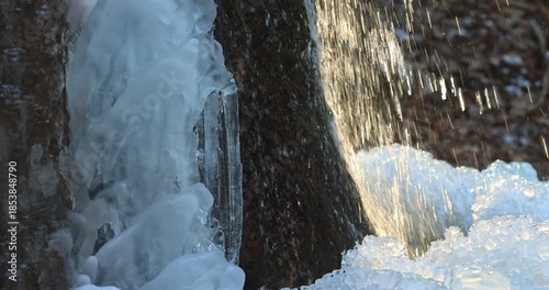 Wallpaper Mural Close-up of icy rocks and water cascading over them, creating a beautiful winter scene. The ice glistens in the sunlight, showcasing the natural beauty of a cold winter day. Torontodigital.ca