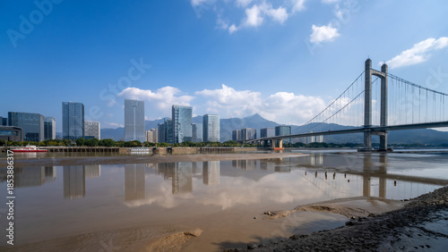 Tableau sur toile Modern city skyline with suspension bridge over river