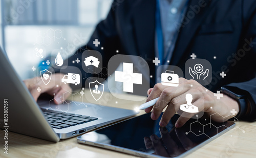 Medical service and health insurance concept with doctor working on laptop and tablet, showing digital healthcare icons and telemedicine technology.